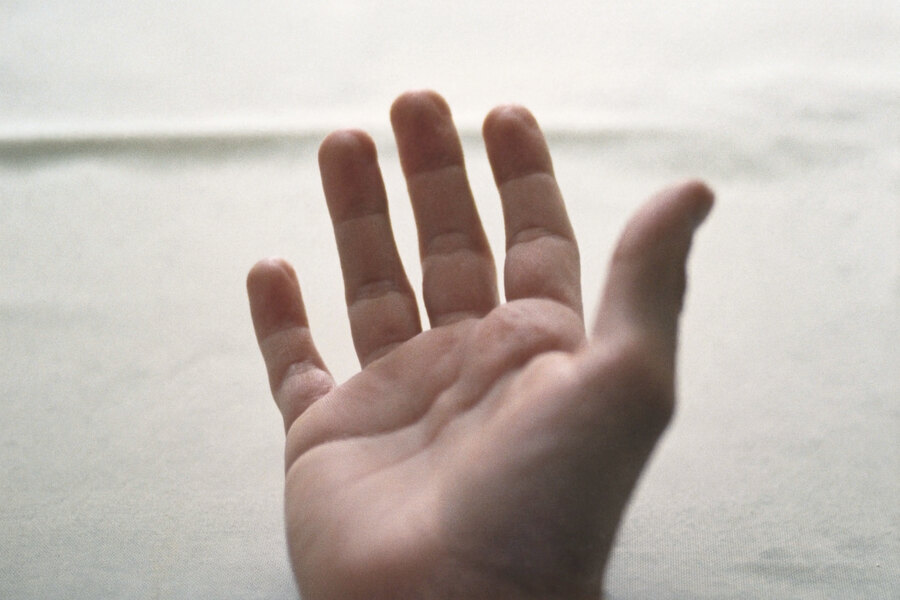 Eine geöffnete, leere Hand auf hellem Tuch.